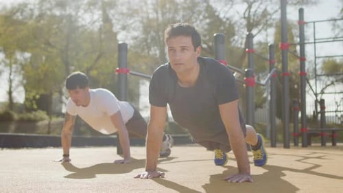 Two Men Doing Pushups at Outdoor Gym