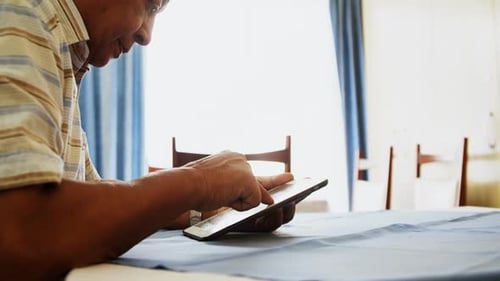 Man Using Tablet Device in Brightly Lit Room