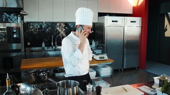 The chef is talking on the phone in the kitchen., People Stock Footage ...