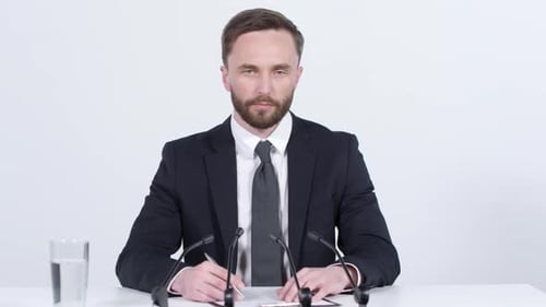 Serious Man in Suit Speaking at Press Conference