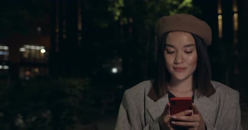 Attractive Woman Using Smartphone and Than Looking To Camera While Walking at Street. Stylish Female