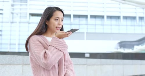 Woman using smartphone on city street