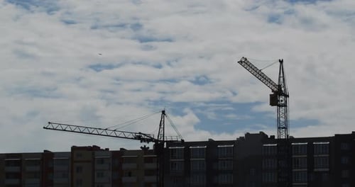 Working cranes on the construction site of a new house Timelapse.