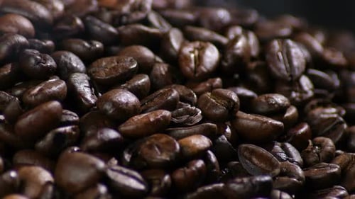 Close-Up of Roasted Coffee Beans with Swirling Vapor