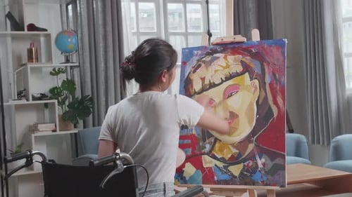 Artist in Wheelchair Painting Colorful Portrait at Home
