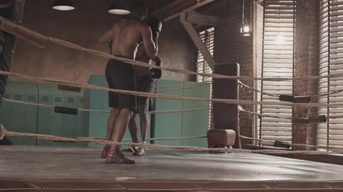 Schwarze männliche Boxer kämpfen auf Ring