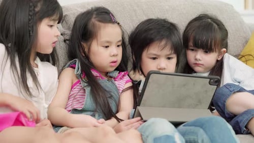 Multi-ethnic young boys and girls happy using technology for study and play games.