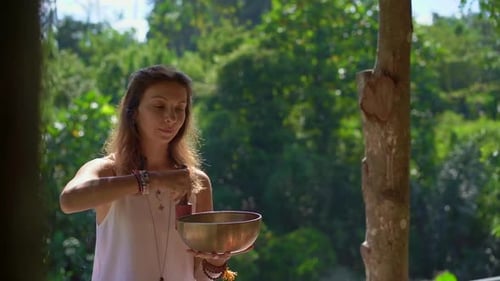 Woman Plays Singing Bowl in Tropical Nature
