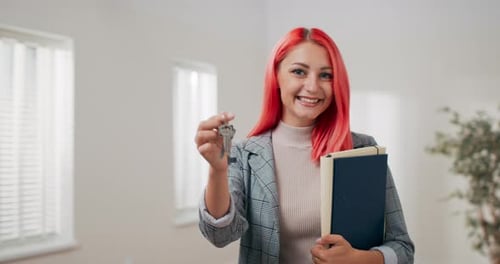 Shot of Apartment Keys Extended on Hand Toward Camera Pinkhaired Woman Dressed in Suit Holds