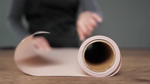 Florist Unrolls Craft Paper on Wooden Table to Wrap Flowers