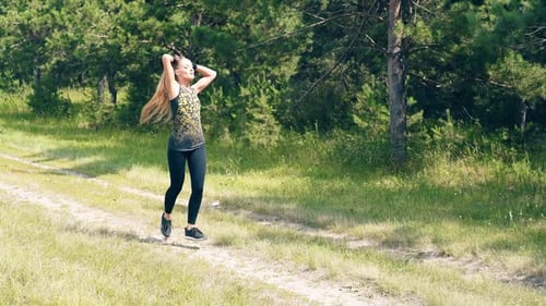 Young Girl Goes in for Sports in the Morning, Runs Along a Pine Forest. Collects Magnificent Hair in