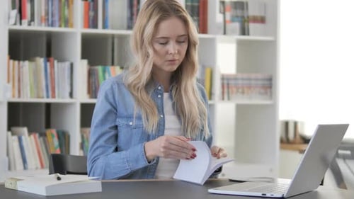 Young Woman Reading Book in Library