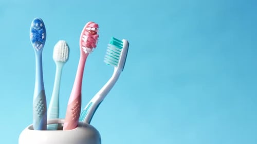 Colorful Toothbrushes in a Holder on Blue Background