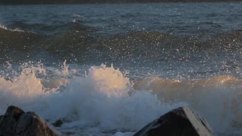 The Waves Crashing Against the Rock on the Sea Shore on the Sunset