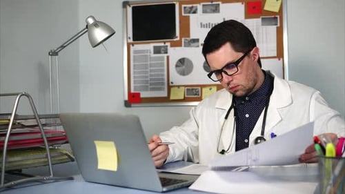 A Young Doctor Signs Documents at the End of the Day at the Polyclinics