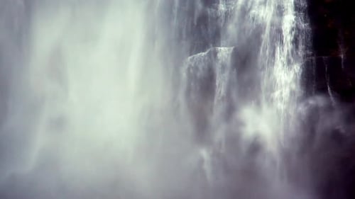 Sheets of water and mist splashing down the mountain in the form of a powerful waterfall