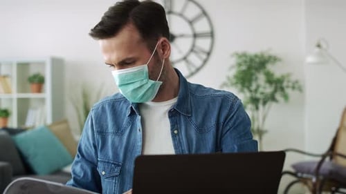Man Wearing Face Mask Works from Home