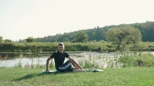 Stretching exercises. Man doing stretching exercises outdoor in summer park.