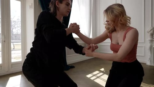 Young Blonde Woman and Her Dance Partner are Rehearsing in Dance Hall