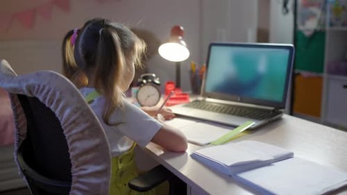 Young Student Diligently Working at Desk