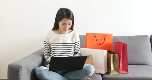 Woman on Couch Shopping Online with Laptop