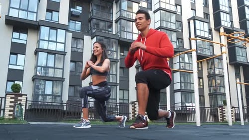 Young Adults Exercising in front of Apartment Building