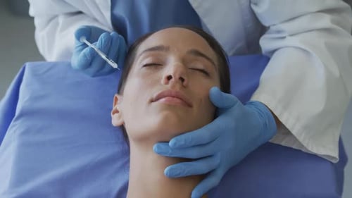 Medical Professional Injecting Young Adult Woman's Face