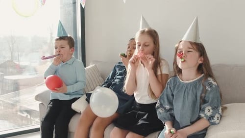 Happy Children Celebrate with Balloons and Noisemakers