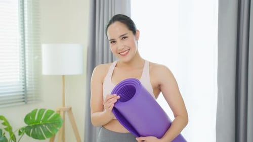 Portrait of Asian woman stand with confidence after exercise in house.