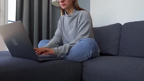 Woman Working on Laptop While Sitting on Couch