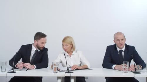 Panel Talking in Meeting at a White Table