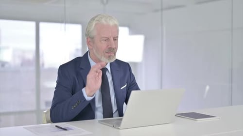 Senior Businessman Using Laptop for Video Conference