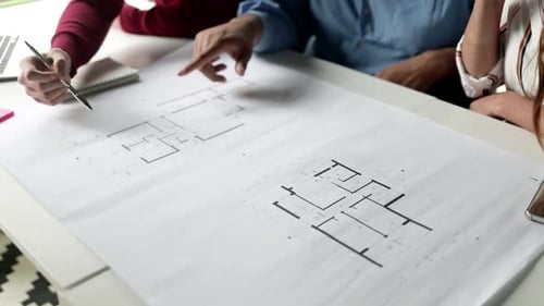 Architects Reviewing Blueprint in Workplace