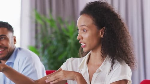 Professional businesswoman talking to her colleagues while sitting in modern office in slow motion