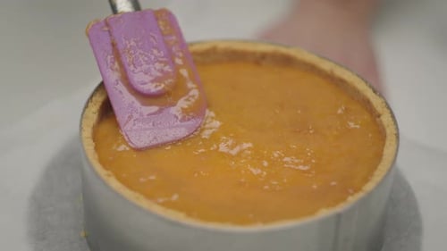 Orange Filling Being Spread into Pie Crust