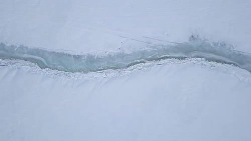 Aerial View of Arctic Ice Fracture in Snowy Landscape
