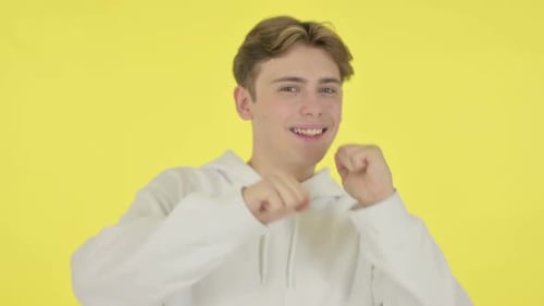 Young Adult Dances in Front of Yellow Background