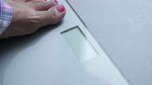 Shiny silver digital health scale using in bathroom atmosphere 4K 2160p 30fps UltraHD footage - Cl