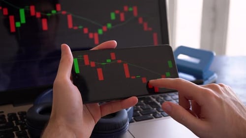 Man Monitors Movement Of Candlestick Bar Chart Of Financial Stock Market. - close up