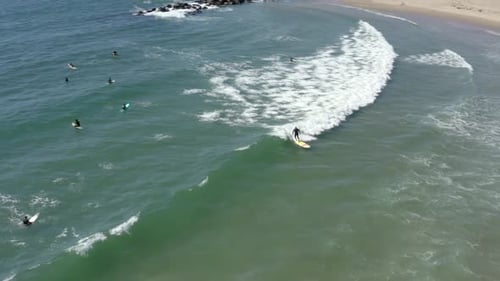 Surfer riding and turning with spray on blue ocean wave, surfing ocean. Aerial