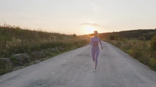 Concetrated Young Lady Runs on the Road in Tracksuit