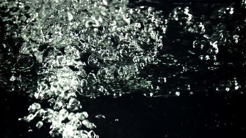 Ein Strahl von Luftblasen unter Wasser steigt nach oben