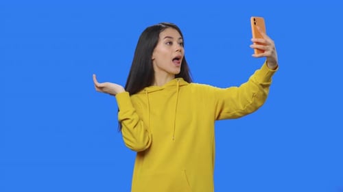 Young Woman Posing for Phone Selfies in Studio