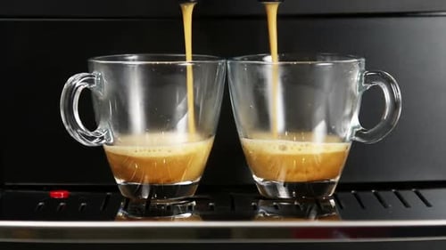 Espresso Pouring into Two Clear Glass Mugs