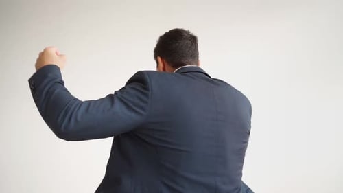 Happy Male Office Worker in Formal Clothes Uses Mobile Phone Rejoices in Victory