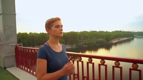 Woman Running on Bridge During Sunrise or Sunset