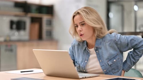 Woman Types on Laptop then Stretches Back