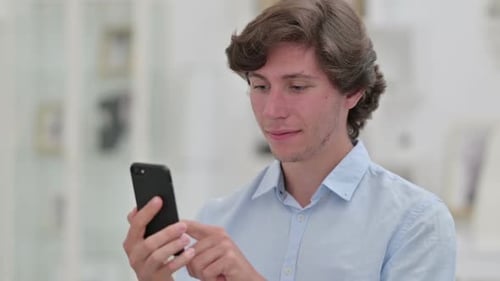 Young Adult Using Smartphone Indoors