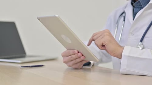 Hands of Doctor Using Tablet Close Up