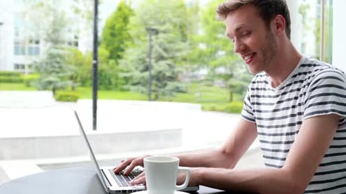 Young Adult Working on Laptop in Urban Setting